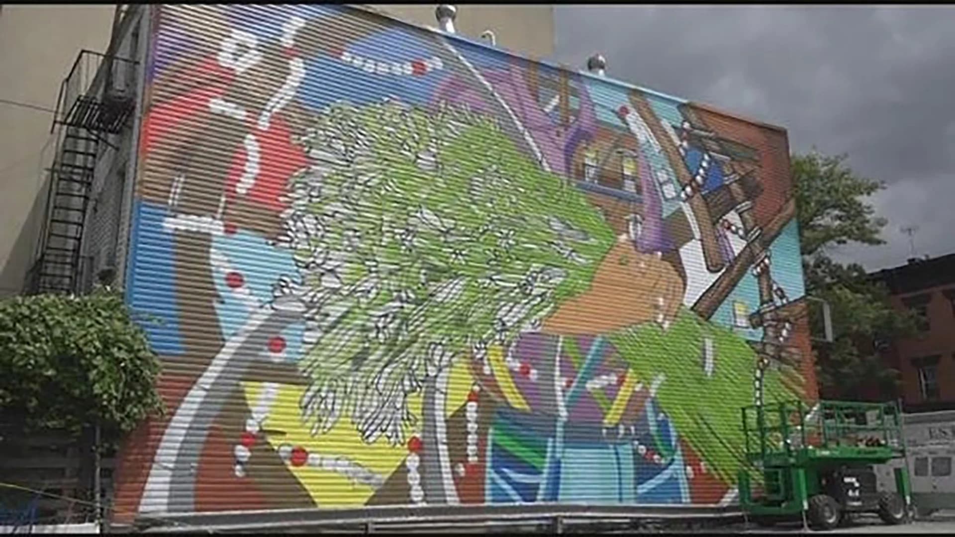 Artist's Grand Street mural honors Puerto Rican-run businesses
